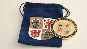 Labelled coin packaging. Blue velvet bag with coat of arms print.